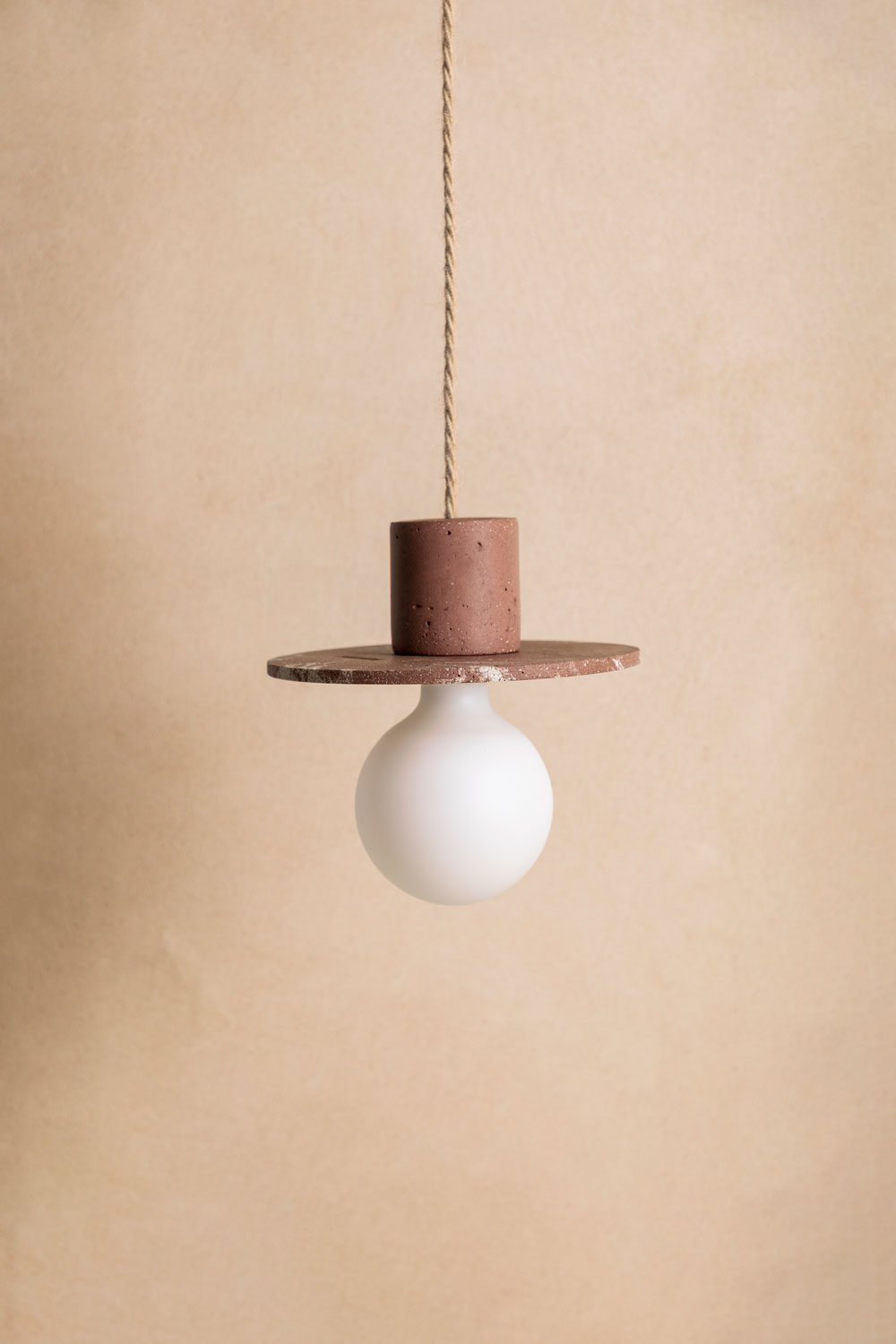 Suspension en béton Alba, teinte Écume Moca. Câble tressé en jute. Douille E27 dorée en laiton. Fabriqué par Atelier Hesmée.