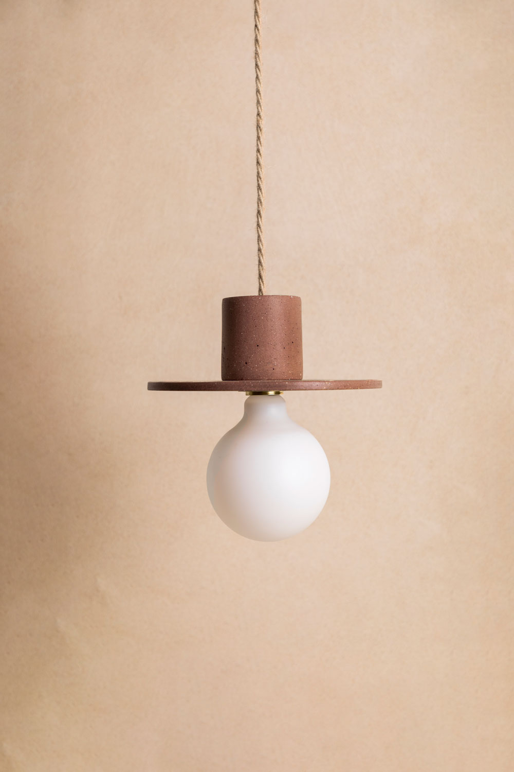 Suspension en béton Alba, teinte Moca. Câble tressé en jute. Douille E27 dorée en laiton. Fabriqué par Atelier Hesmée.