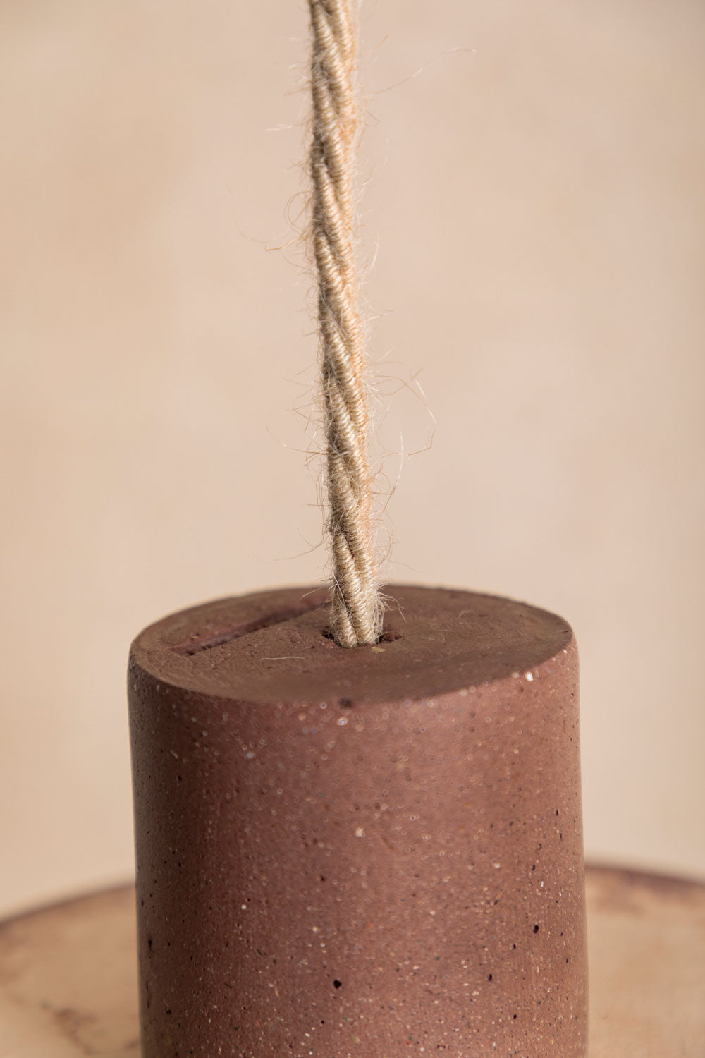 Suspension en béton Alba, teinte Moca, zoom sur le dessus. Câble tressé en jute. Douille E27 dorée en laiton. Fabriqué par Atelier Hesmée.