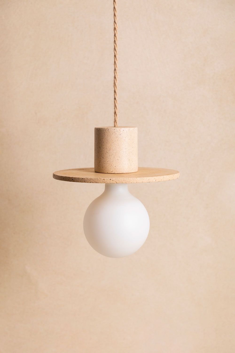 Suspension en béton Alba, teinte Sabbia. Câble tressé en jute. Douille E27 dorée en laiton. Fabriqué par Atelier Hesmée.