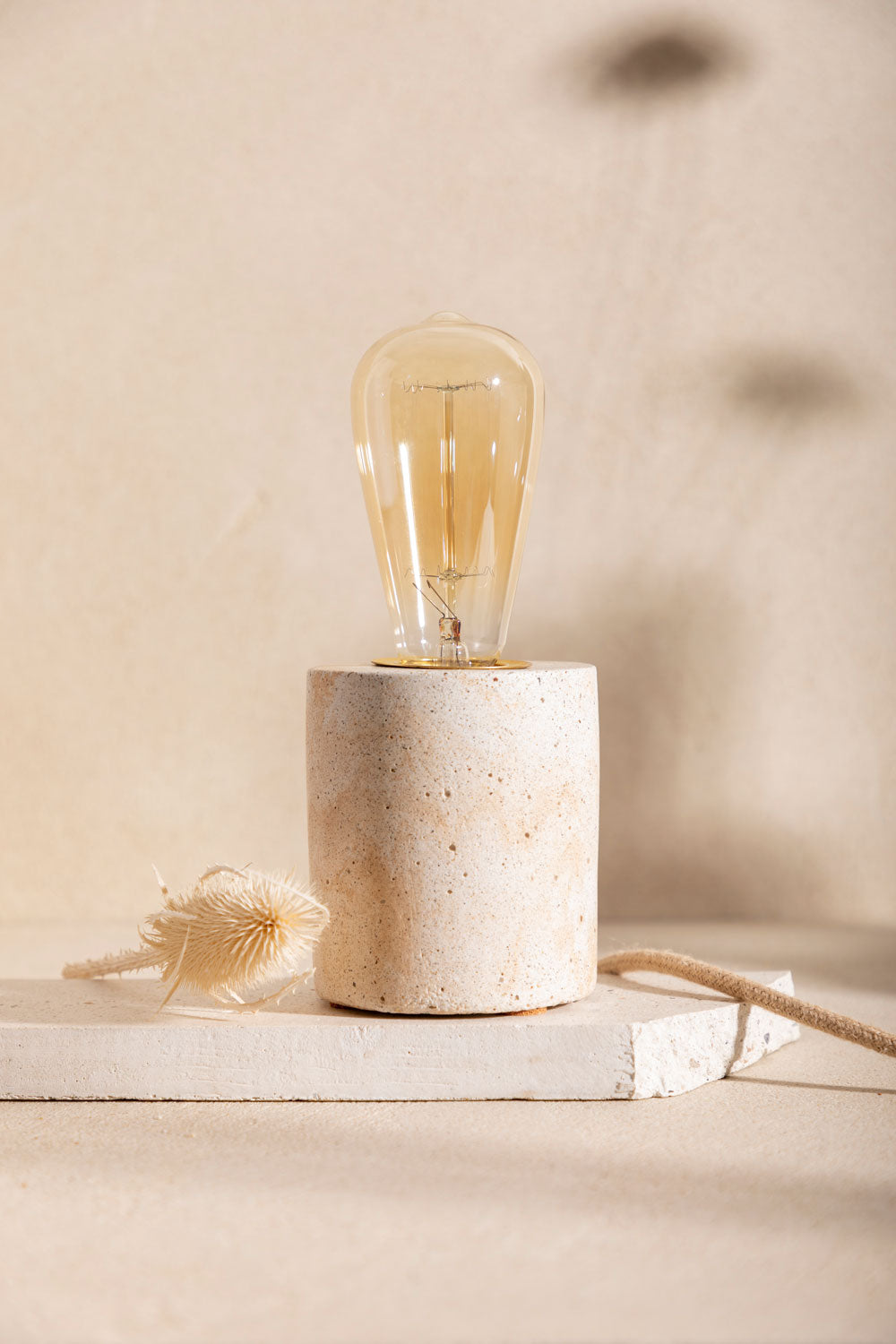 Pied de lampe en béton Luna, teinte Écume Sabbia. Câble en jute. Fabriqué par Atelier Hesmée.