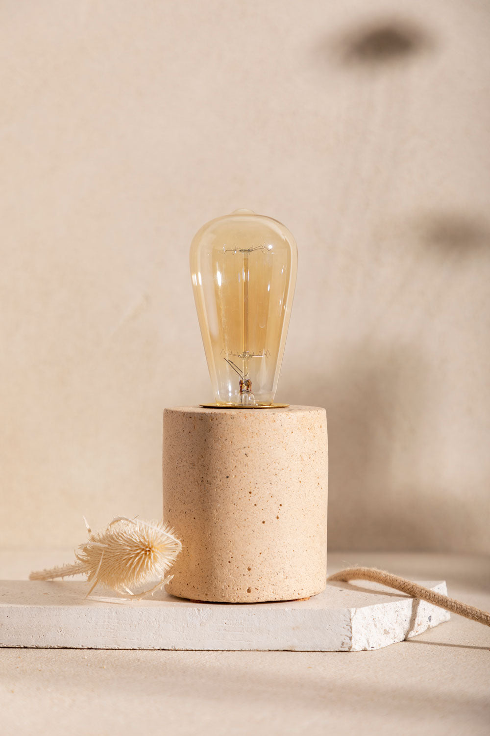 Pied de lampe en béton Luna, teinte Sabbia. Câble en jute. Fabriqué par Atelier Hesmée.