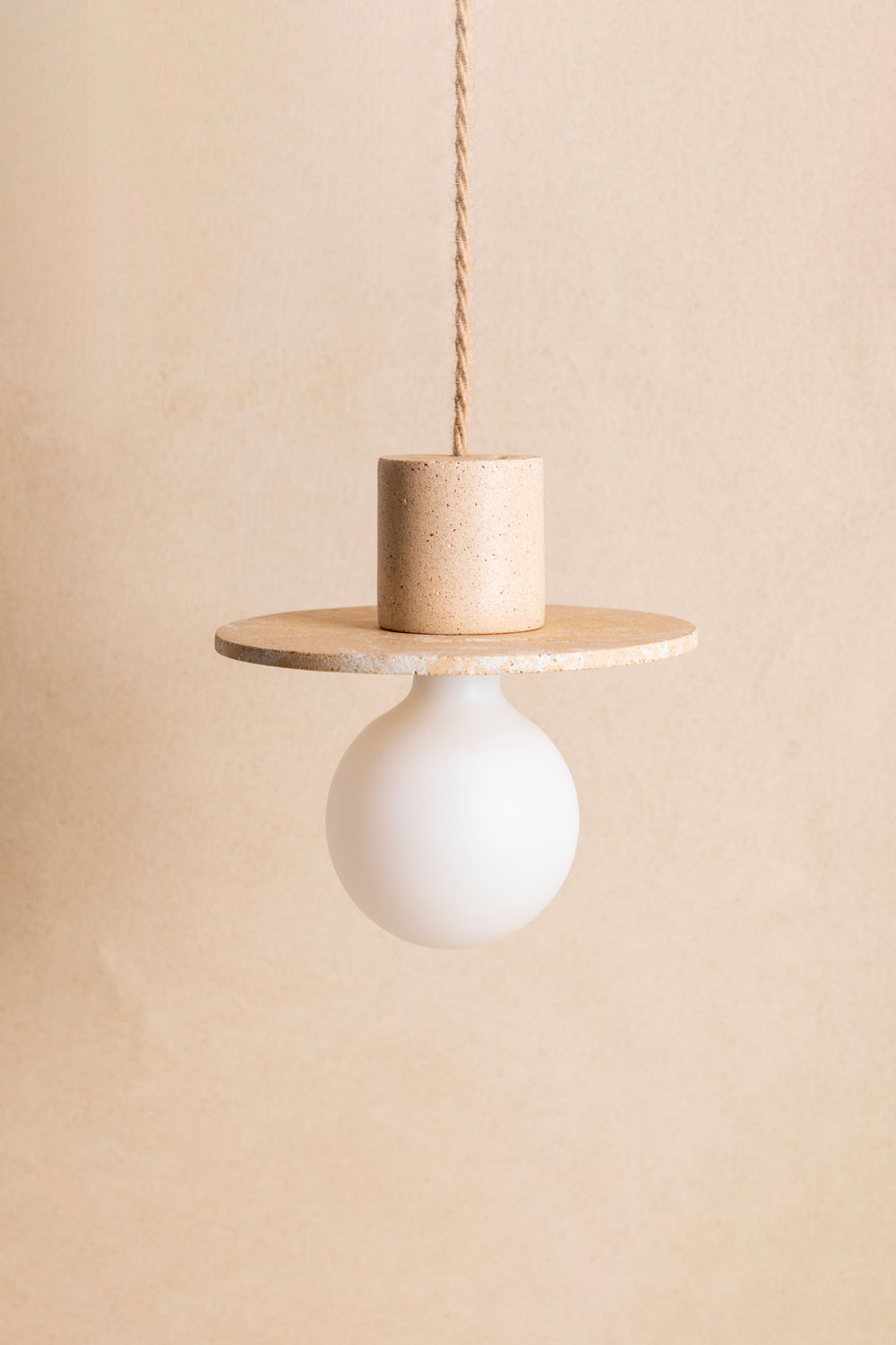 Suspension en béton Alba, teinte Écume Sabbia. Câble tressé en jute. Douille E27 dorée en laiton. Fabriqué par Atelier Hesmée.