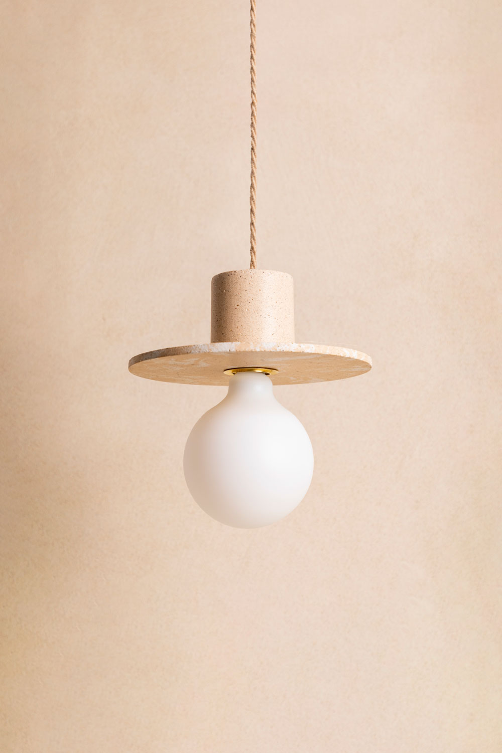 Suspension en béton Alba, teinte Écume Sabbia. Câble tressé en jute. Douille E27 dorée en laiton. Fabriqué par Atelier Hesmée.