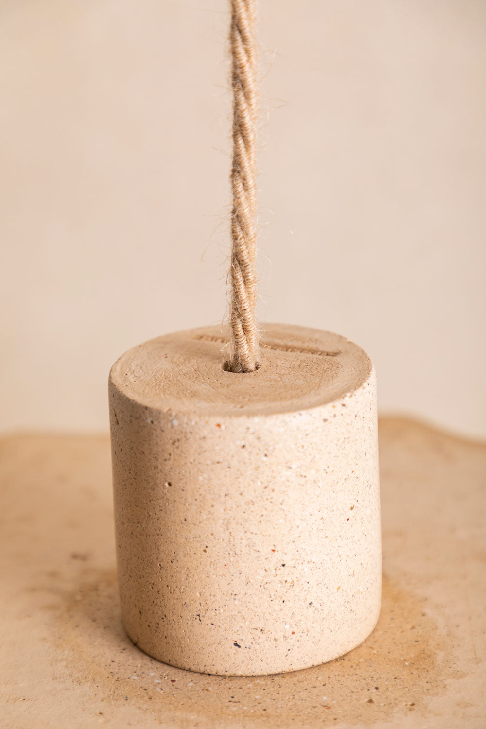 Suspension en béton Ella, taille S, vue du dessus, teinte Sabbia. Câble tressé en jute. Douille E27 dorée en laiton. Fabriqué par Atelier Hesmée.